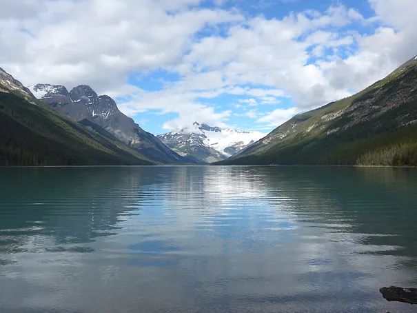 A partially cloudy view of Glacier Lake in the daytime
